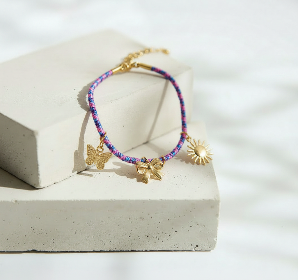 Pulsera Tejida Multicolor con Dijes Dorados de Moño Sol y Mariposa - Acero Inoxidable